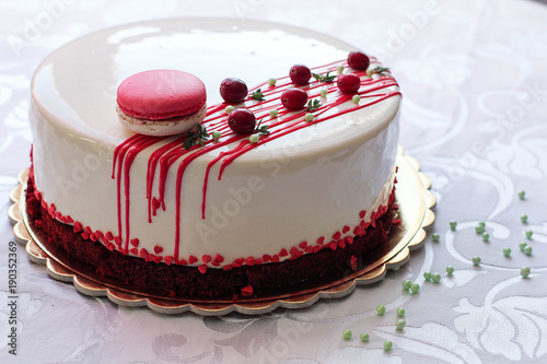 Foto Tasty white homemade cake decorated by red berries and macaron