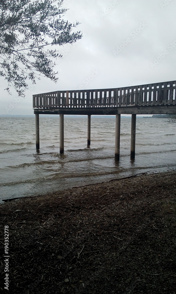 Obraz premium Holzsteg am Chiemsee in Chieming im düsteren Herbst