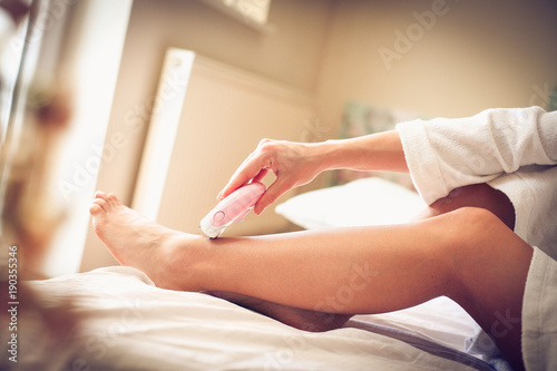 Depilation legs on bed. Morning is for body care.