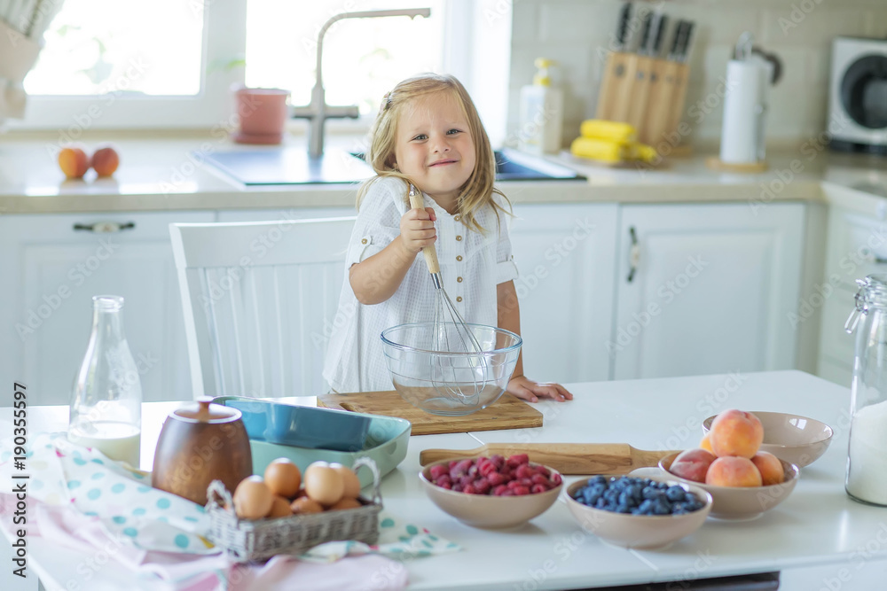 The child is cooking in the kitchen The child is cooking in the kitchen