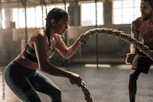 Fototapeta Naklejka Na Ścianę i Meble -  Young woman working out with battle ropes