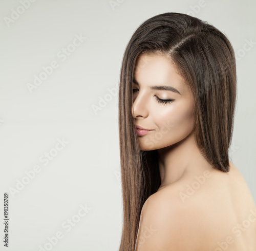 Young Attractive Model Woman with Long Hair and Nude Makeup on Background with Copy space