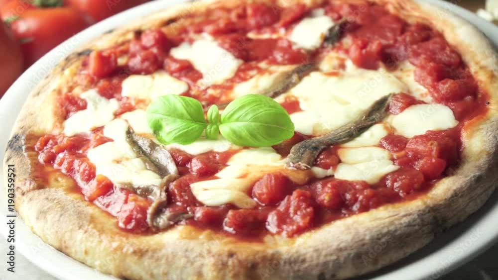 Pizza with tomato mozzarella cheese and anchovies on the table Pizza with tomato mozzarella cheese and anchovies on the table