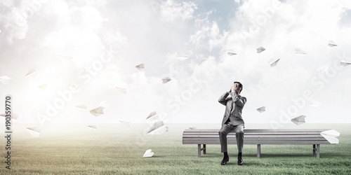 Young man in summer park on bench do not want to see anything