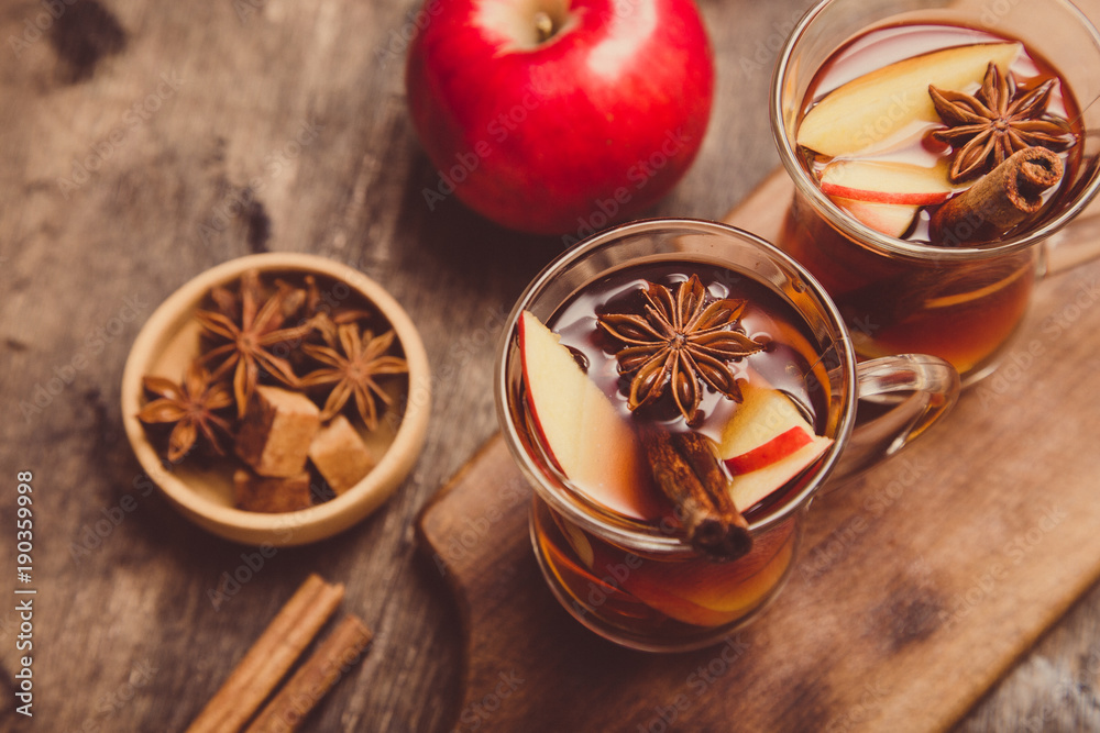 Fototapeta premium hot spicy beverage. Hot drink (apple tea, punch) with cinnamon stick and star anise. Seasonal mulled drink