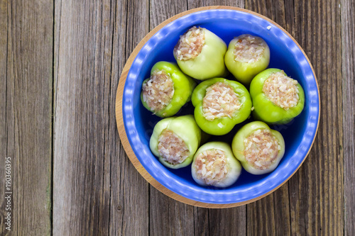 Raw peppers stuffed with meat on a wooden cutting board photo