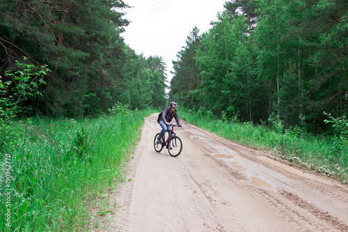 The man on a bicycle. Tourist base in the forest. © ferkhova