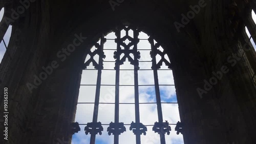 The arch windows of the ruins of Melrose Abbey in Scotland and clouds