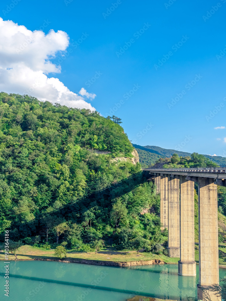 bridge above calm turquoise river in georgian mountains bridge above calm turquoise river in georgian mountains