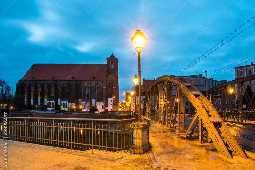 Mlynski bridge and Church of the Blessed Virgin on the Piasek island at night in Wroclaw, Silesia, Poland