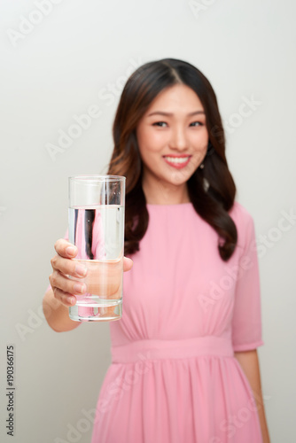 Young asian beautiful woman showing the glass of water.