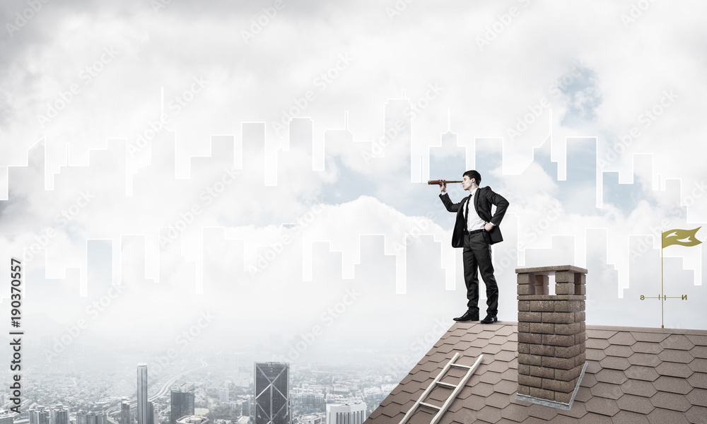 Engineer man standing on roof and looking in spyglass. Mixed med Engineer man standing on roof and looking in spyglass. Mixed med