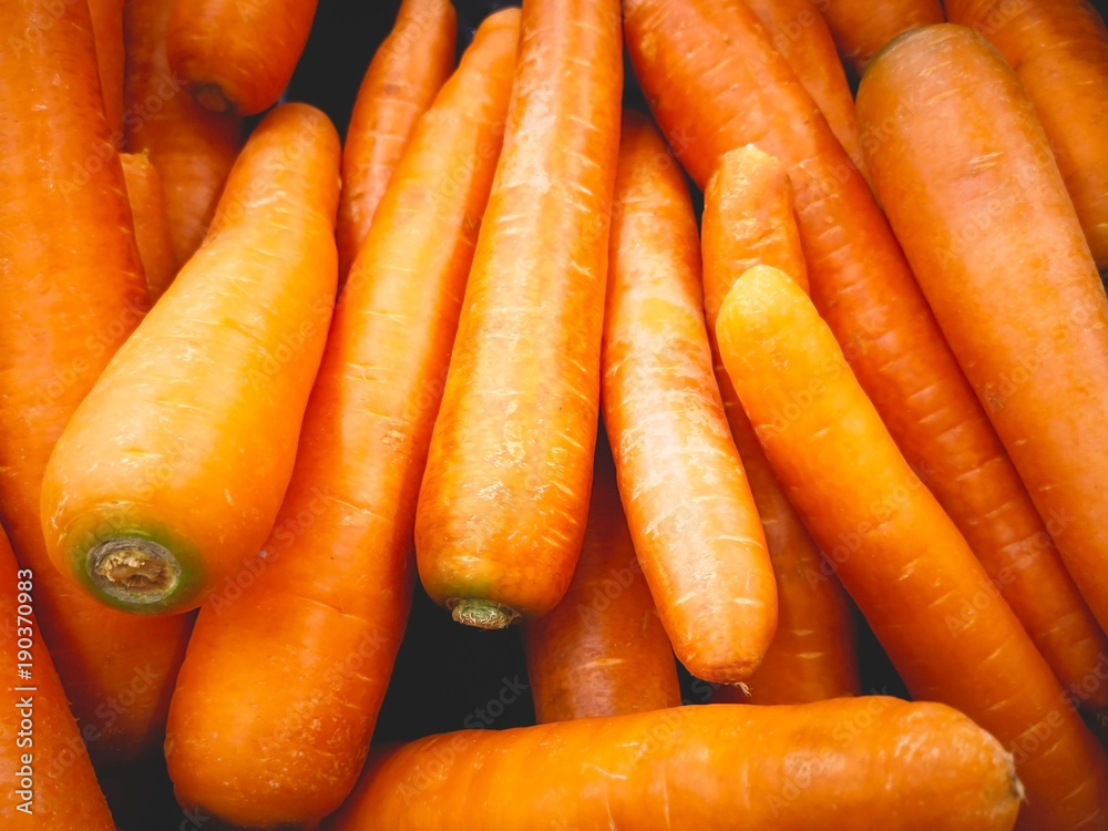 Vegetable concept. Many carrots are in a rattan basket for sale in supermarket. Selective focus, full frame and copy space. Vegetable concept. Many carrots are in a rattan basket for sale in supermarket. Selective focus, full frame and copy space.