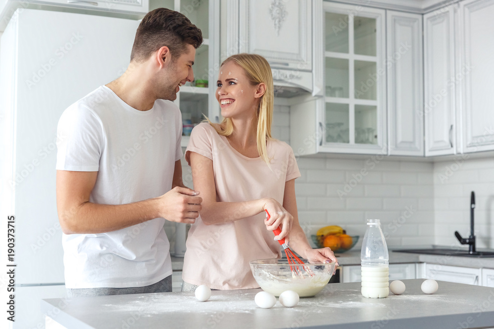 young couple cooking breakfast together on kitchen young couple cooking breakfast together on kitchen