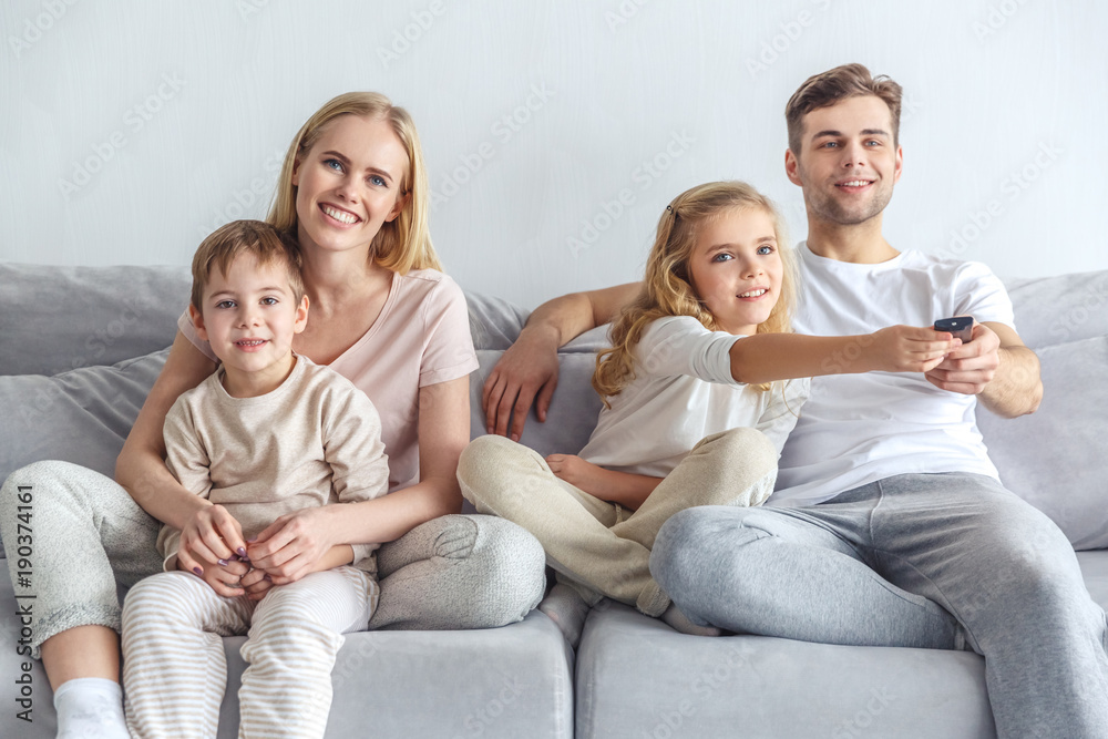 happy young family watching movie at home on weekend