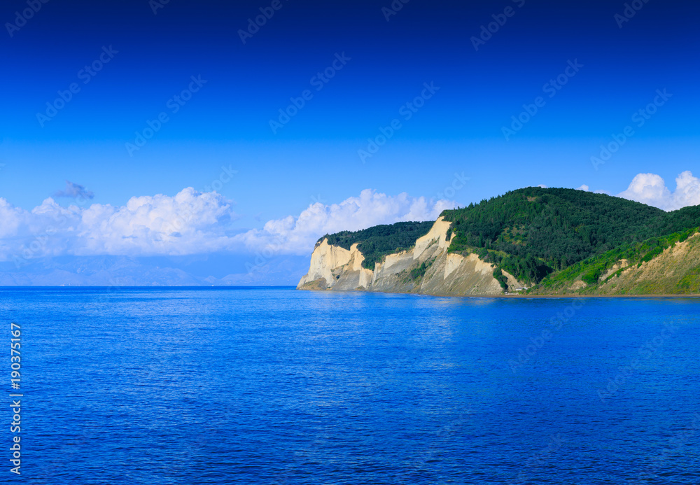 Beautiful summertime panoramic seascape. View of the crystal clear azure sea bay and limestone cliffs. Agios Stefanos cape. Ag. Stefanos. Corfu. Greece. Beautiful summertime panoramic seascape. View of the crystal clear azure sea bay and limestone cliffs. Agios Stefanos cape. Ag. Stefanos. Corfu. Greece.