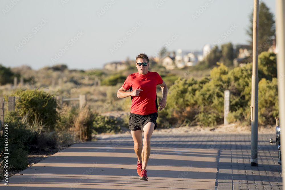 young attractive and happy sport runner man with fit and strong healthy body training on off road track in Summer running workout young attractive and happy sport runner man with fit and strong healthy body training on off road track in Summer running workout