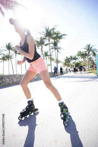 Trendy girl roller-skating in Miami South Beach promenade
