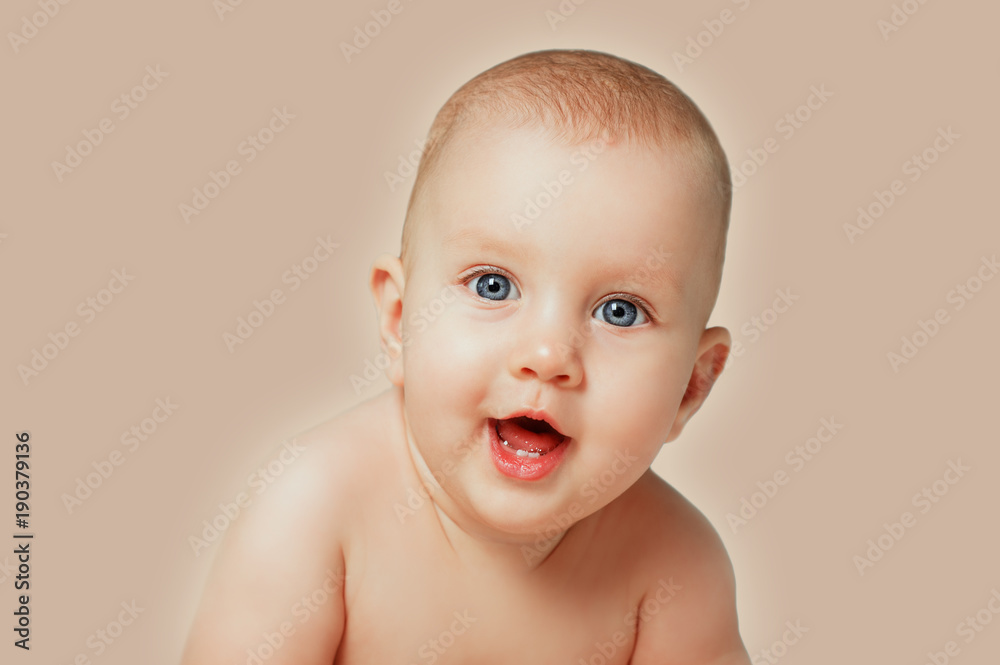 Close-up portrait of adorable newborn baby smiling on isolated beige background. People Lifestyle Family Kids Emotions concept. Sweet infant in bedroom looking to cam. Close-up portrait of adorable newborn baby smiling on isolated beige background. People Lifestyle Family Kids Emotions concept. Sweet infant in bedroom looking to cam.