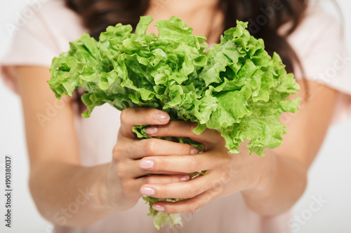 Close up of a woman showing lettuce leaves