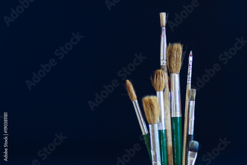 Closeup of paintbrushes isolated on blue background