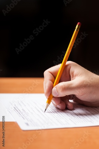 Student Filling Out Answers to a Test with a Pencil
