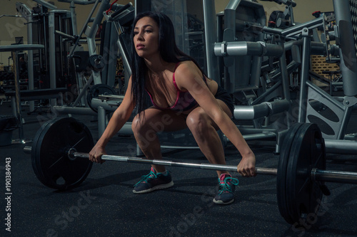 Athlete squats with a barbell in the gym. Sport life