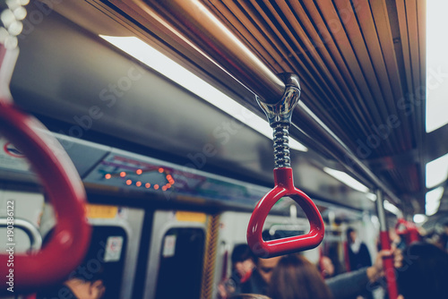 People were traveling By holding the handrails on the subway in Hong Kong photo