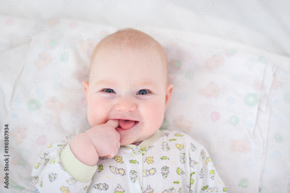 Funny baby holds a finger in his mouth and smiles Funny baby holds a finger in his mouth and smiles