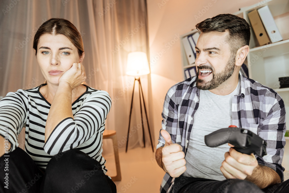 Obraz premium I win. Happy bearded man opening mouth and raising thumb up while looking at his friend