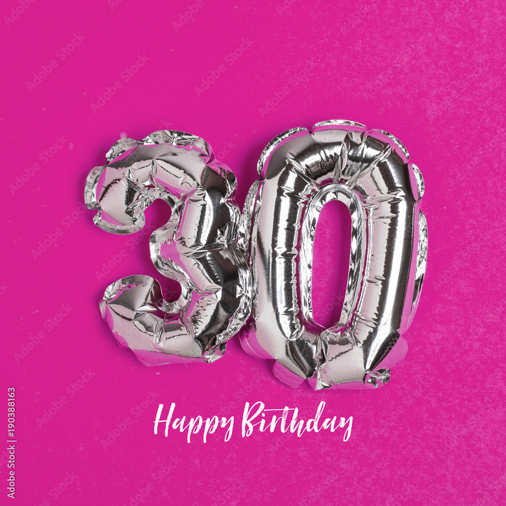 Silver foil number 30 celebration balloon on a bright yellow background Silver foil number 30 celebration balloon on a bright yellow background