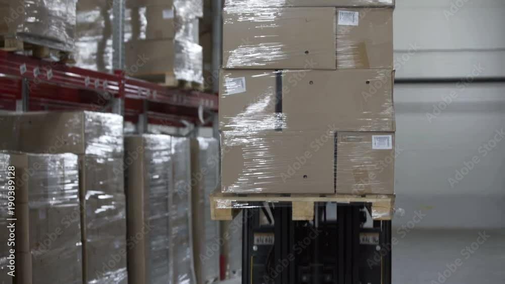 Forklift Trucks unload Pallets with Cardboard Boxes at modern warehouse