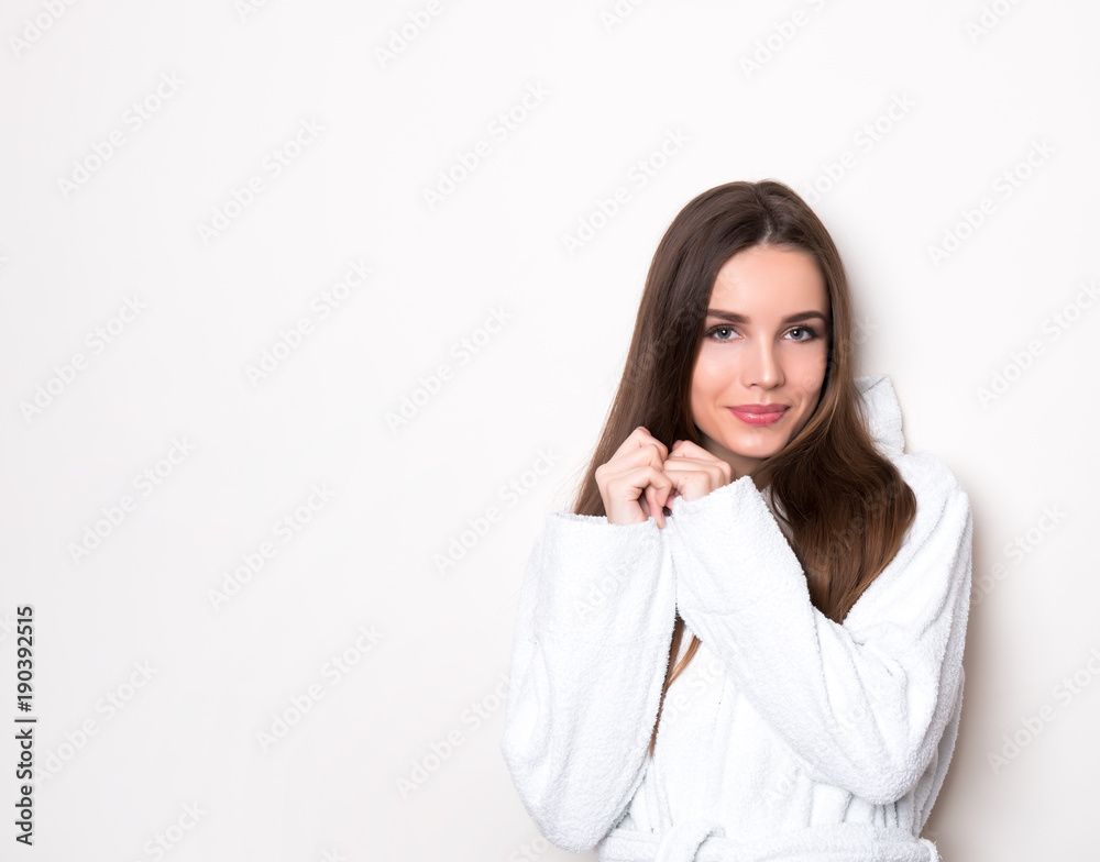 beautiful young woman wearing a bath robe and posing on background with copy space beautiful young woman wearing a bath robe and posing on background with copy space