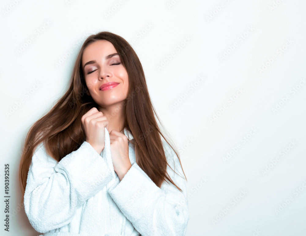 beautiful young woman wearing a bath robe and posing on background with copy space beautiful young woman wearing a bath robe and posing on background with copy space