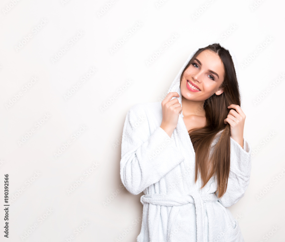 beautiful young woman wearing a bath robe and posing on background with copy space beautiful young woman wearing a bath robe and posing on background with copy space