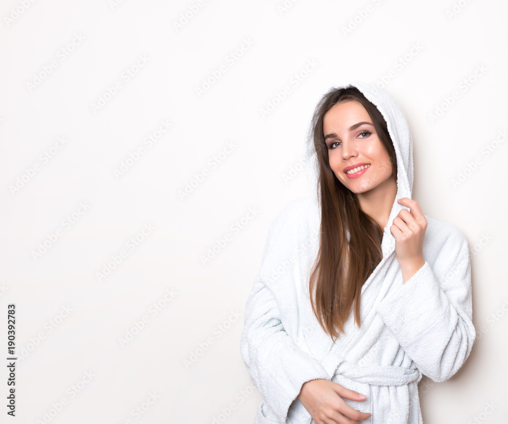 beautiful young woman wearing a bath robe and posing on background with copy space beautiful young woman wearing a bath robe and posing on background with copy space