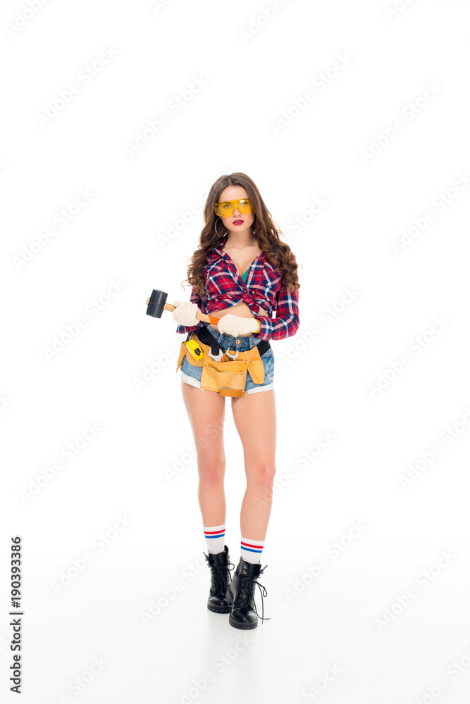 beautiful girl in goggles and gloves with tool belt holding hammer, isolated on white beautiful girl in goggles and gloves with tool belt holding hammer, isolated on white