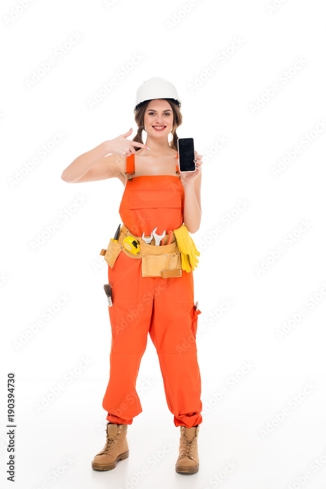 smiling workwoman in uniform pointing at smartphone with blank screen, isolated on white smiling workwoman in uniform pointing at smartphone with blank screen, isolated on white