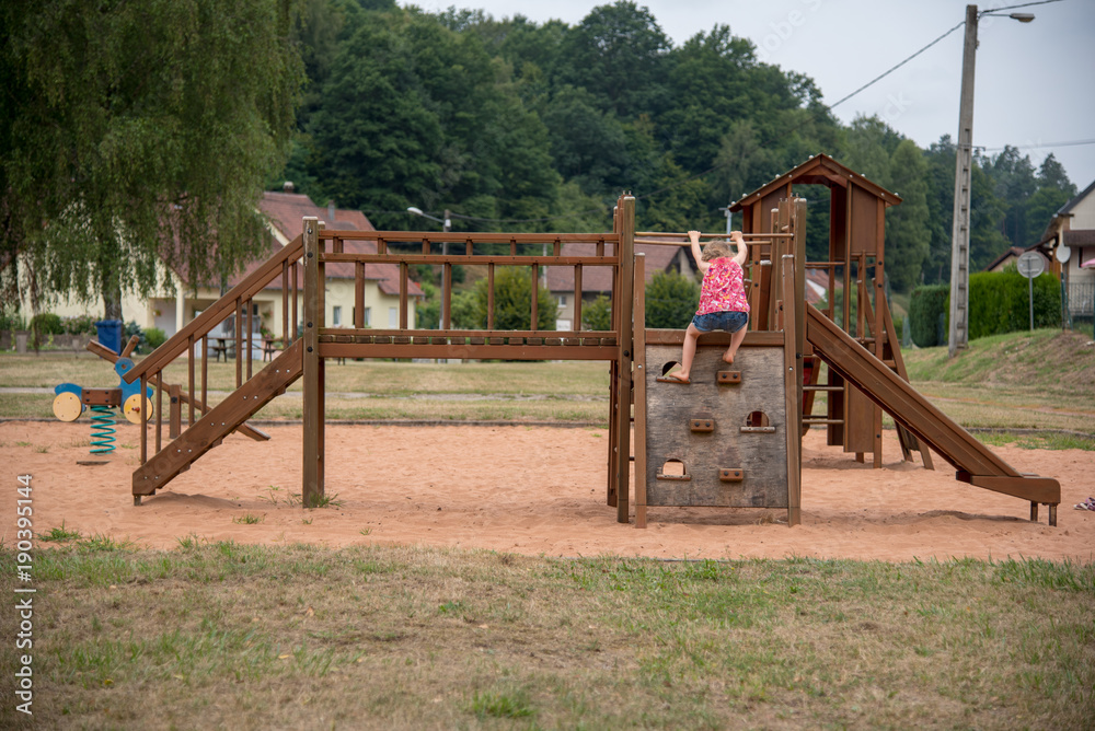 Girl climbing on wooden public games, France. Girl climbing on wooden public games, France.