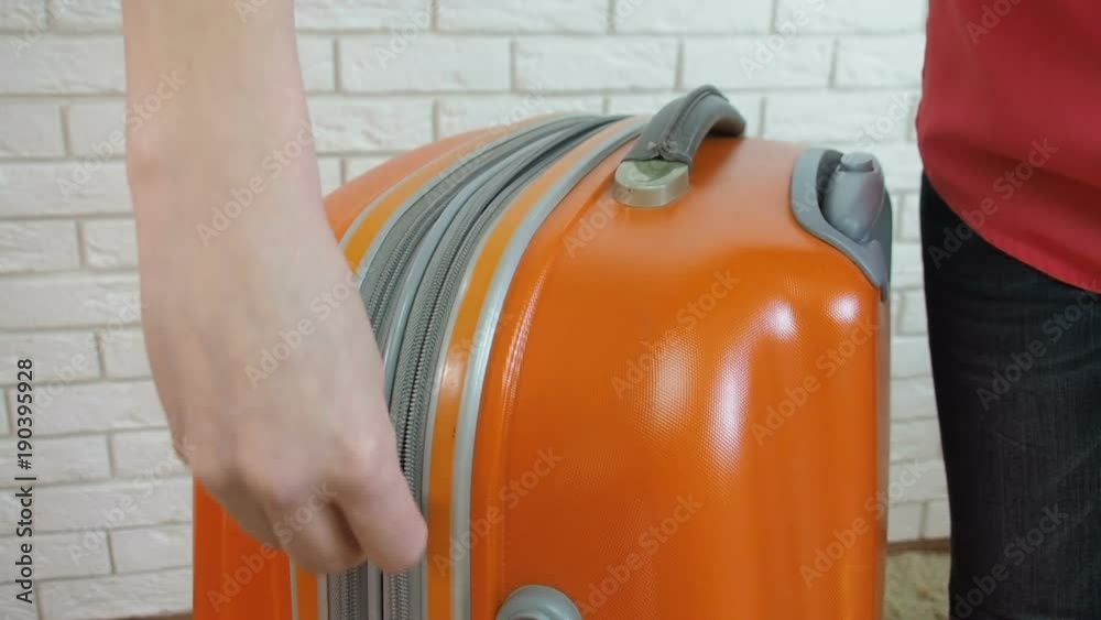 Travel bag. The woman is buttoning her suitcase. Travel bag. The woman is buttoning her suitcase.