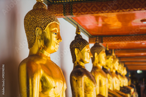 Row of golden statues of Buddha in Thailand temple
