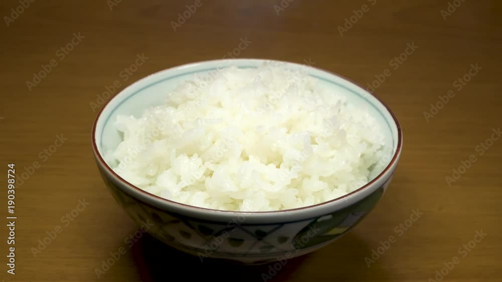 Plain HOT STEAMED WHITE RICE in the bowl on table. Plain HOT STEAMED WHITE RICE in the bowl on table.