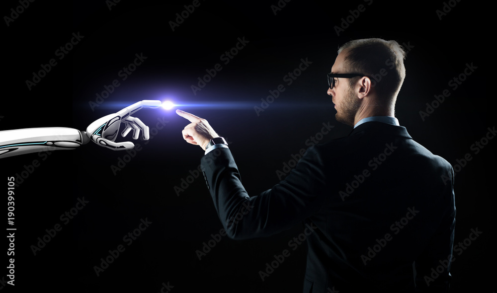 robot and human hand flash light over black robot and human hand flash light over black