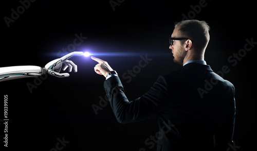 robot and human hand flash light over black