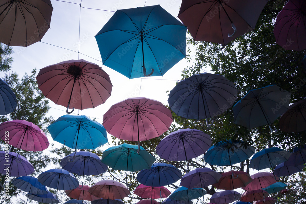Silhouette of colorful umbrellas hanging above the street