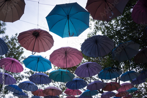Silhouette of colorful umbrellas hanging above the street