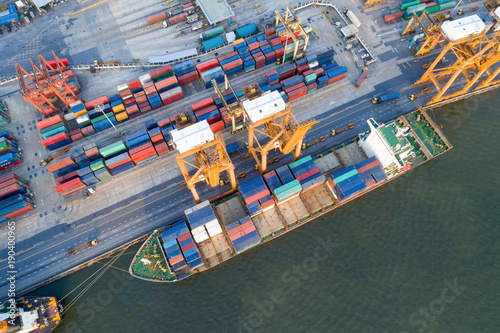 Containers yard in port congestion with ship vessels are loading and discharging operations of the transhipments in international port.