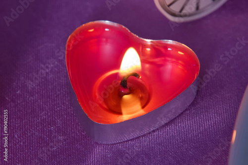Candles red hearts with small hearts . Pink background . Red heart shaped candles burning Valentines day concept