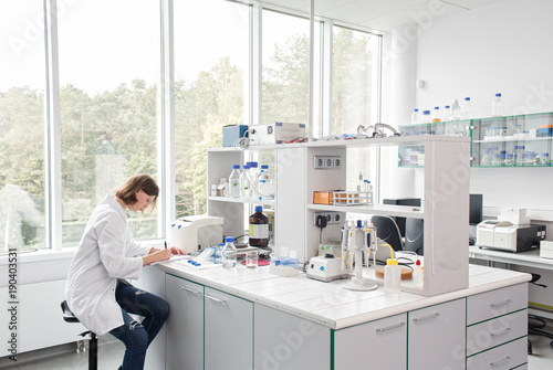 Woman writing in laboratory photo