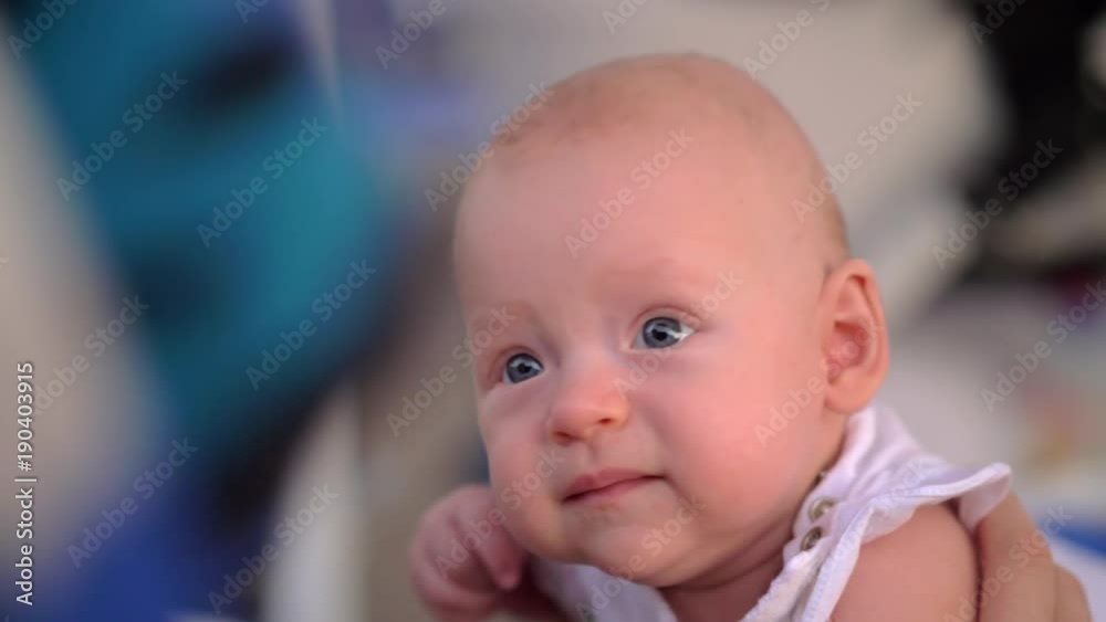 Slow motion close-up shot of three months baby girl. Portrait of cute blue-eyed child Slow motion close-up shot of three months baby girl. Portrait of cute blue-eyed child
